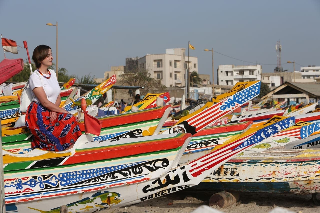 Exterior facade of Le Restaurant du Port in Oussouye, Senegal, showing a building with tables set up near the waterfront