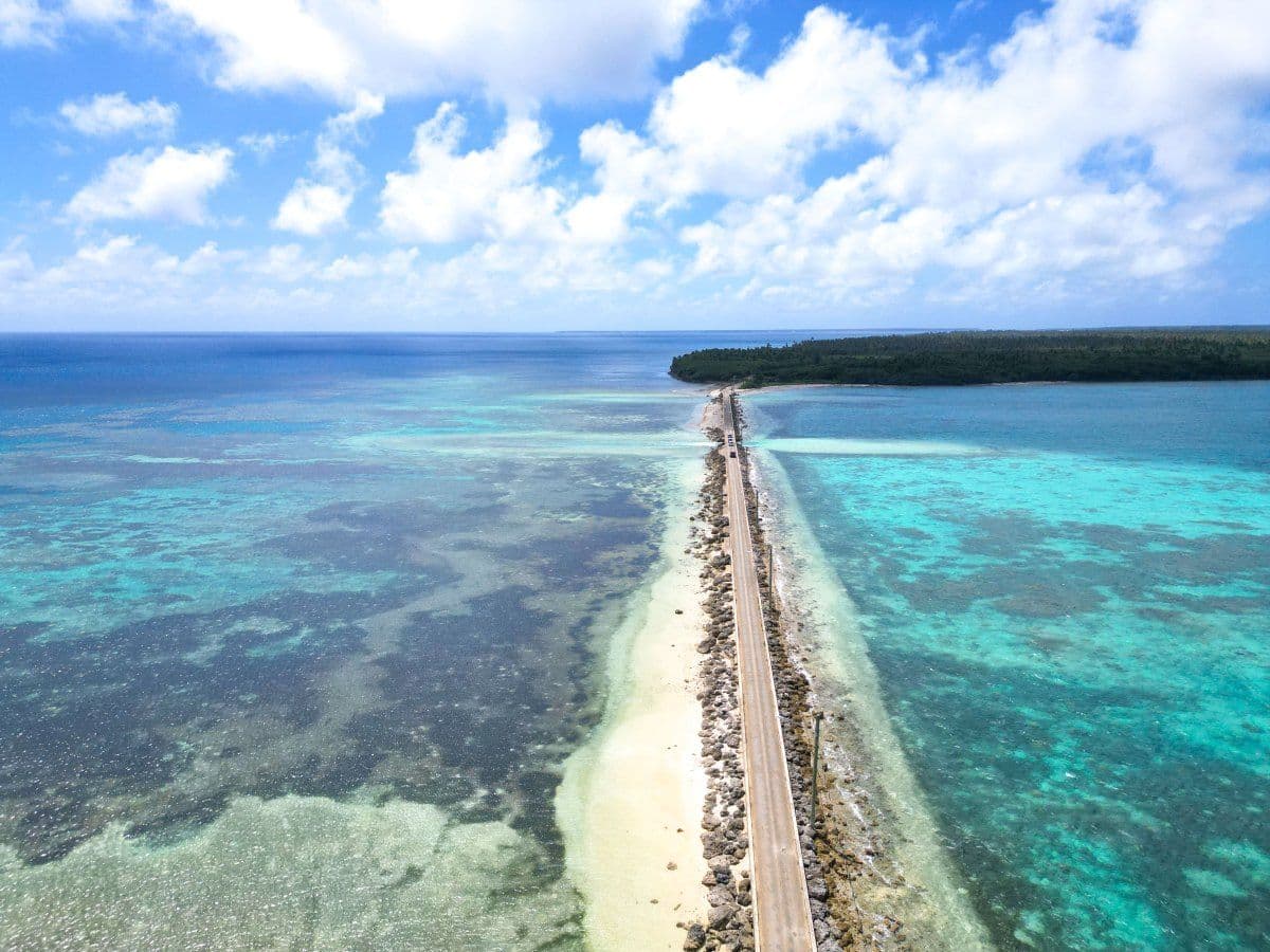 Coastal road causeway in Ha'apai, Tonga with blue sky and vegetation