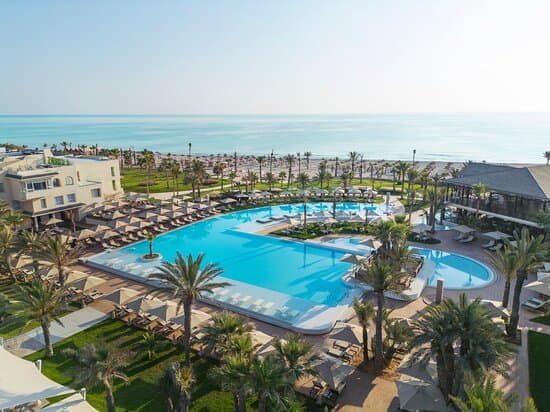 Coastal scene in Hammam Sousse showing sandy beach, turquoise water, and beachfront hotels in spring