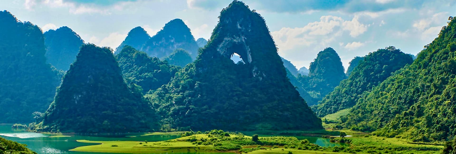 Panoramic view of lush green mountains and winding roads in the Central Highlands of Vietnam