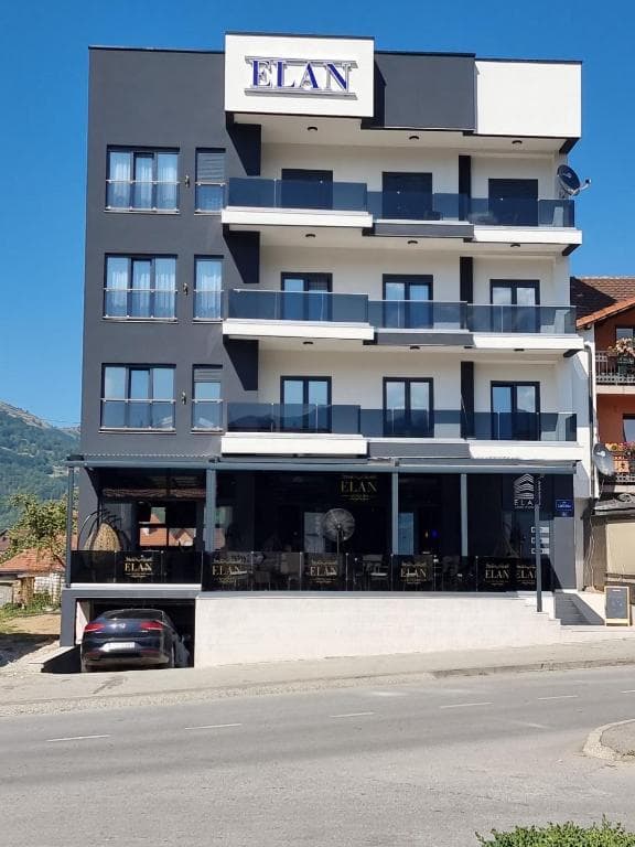 Modern guesthouse exterior in Plav, Montenegro, featuring a contemporary facade with large windows overlooking the lake