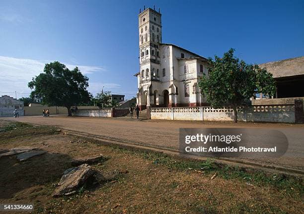 Exterior view of the historic Catholic Church in Aného, Togo, showcasing colonial-era architecture and adjacent market area