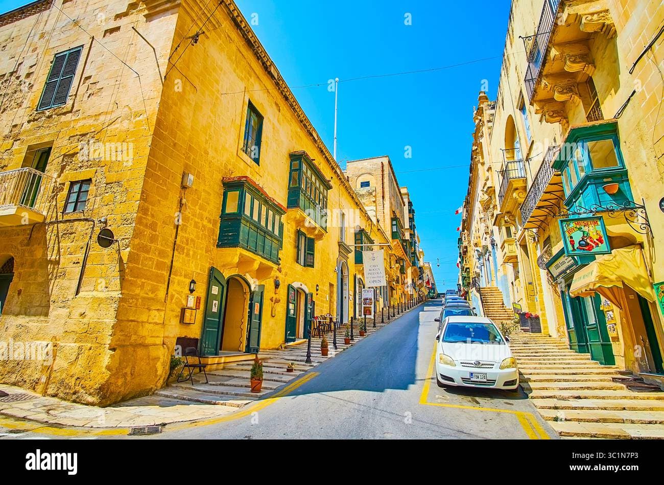 Street view of Republic Street in Valletta, Malta, showing tall limestone buildings and urban architecture
