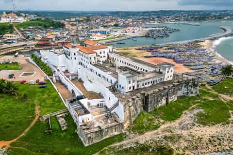 Traditional dance and music performance taking place near Elmina Castle in Ghana