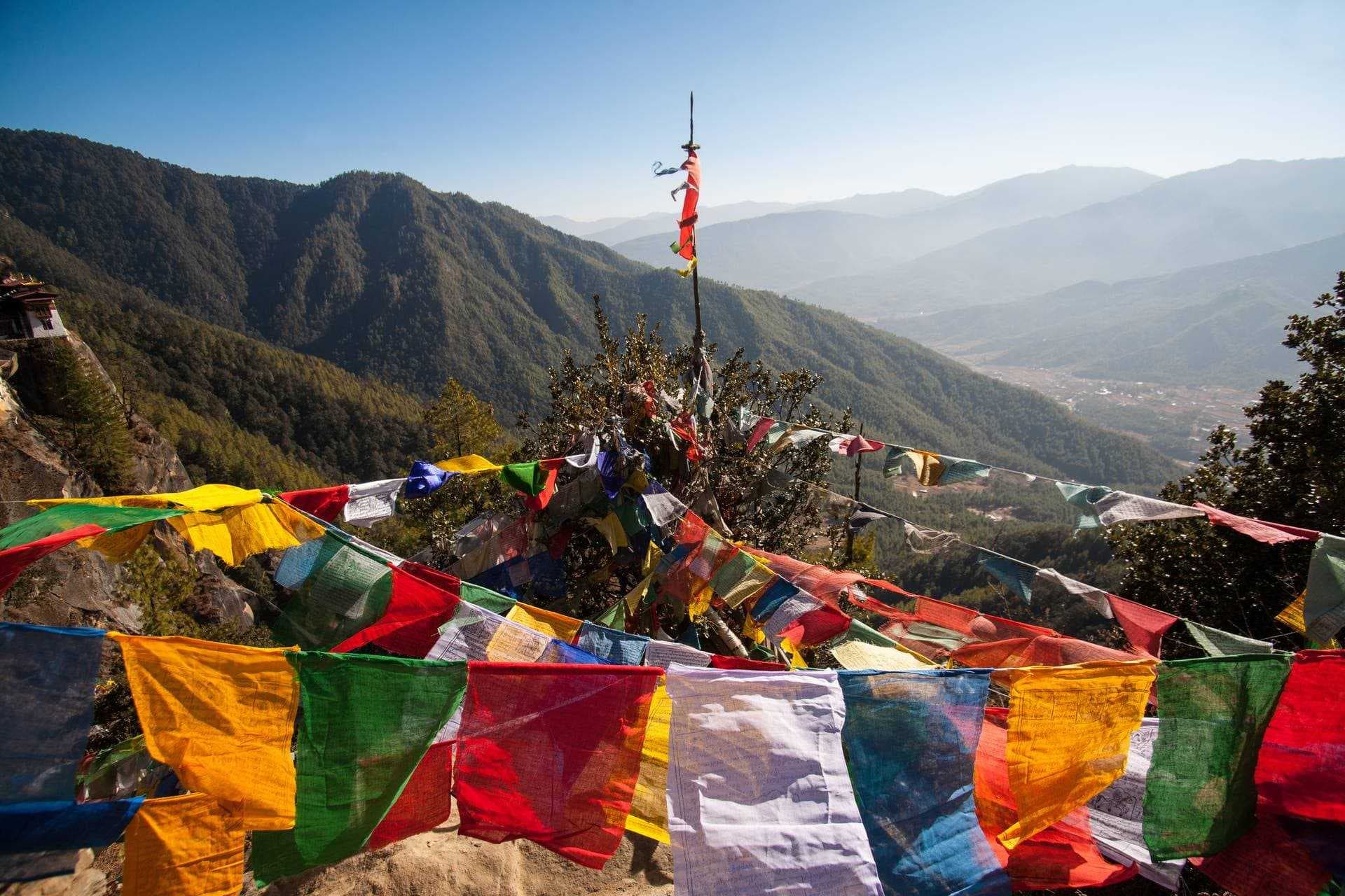 Prayer flags and distant monastery in the mountains of Bhutan