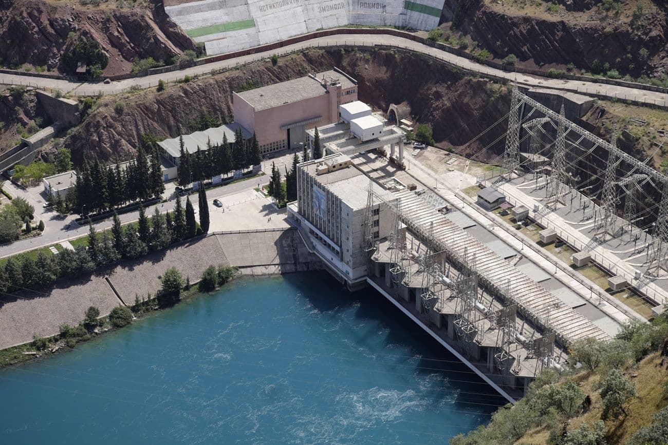 Aerial view of the Nurek Dam reservoir and concrete structure in Tajikistan.