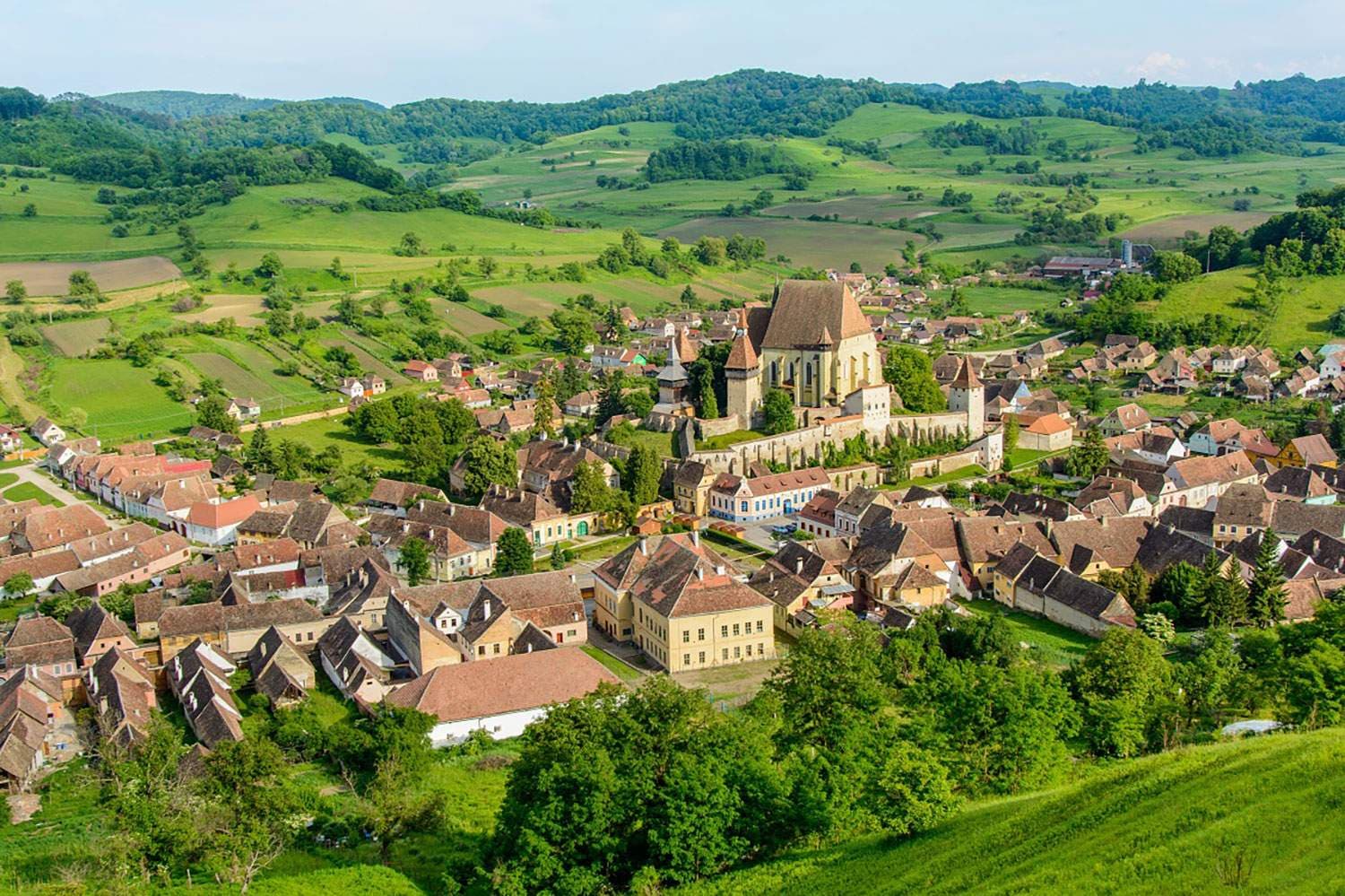 Aerial view of a rural Moldovan village with traditional houses and a fortified church