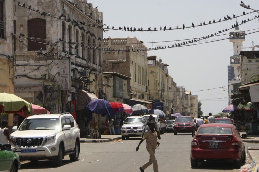 Urban street scene in Djibouti City with historic buildings and local market activity