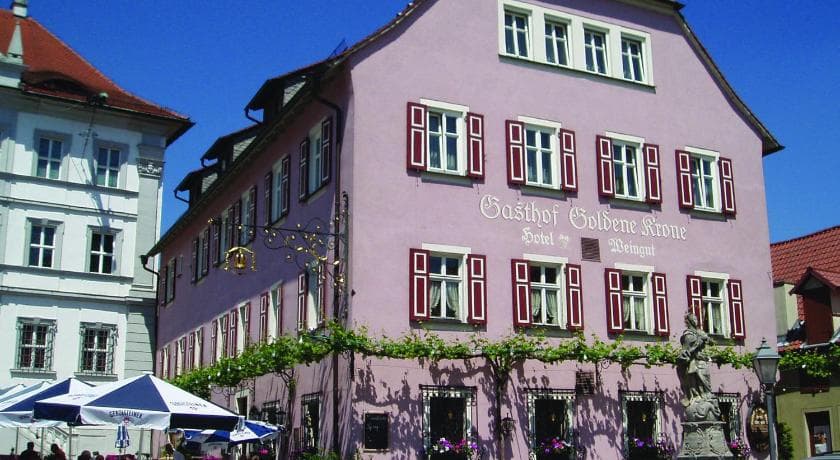 Exterior of Hotel Garni Zum Hirschen in Iphofen, Germany, showing building facade and surrounding landscape