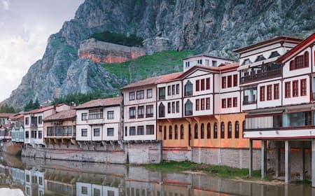 Courtyard of a traditional guesthouse in Merkez, Turkey, featuring wooden balconies and tiled floors
