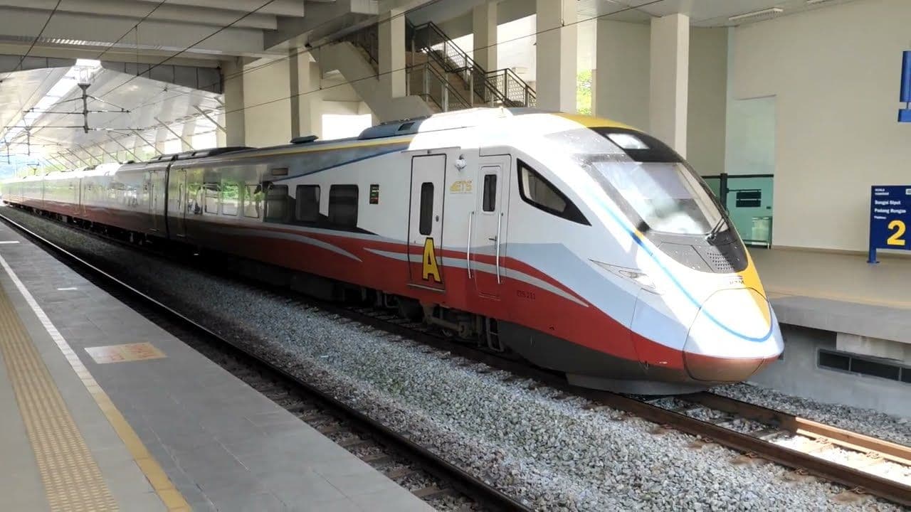 A KTM ETS electric train is stopped at a platform in a modern railway station