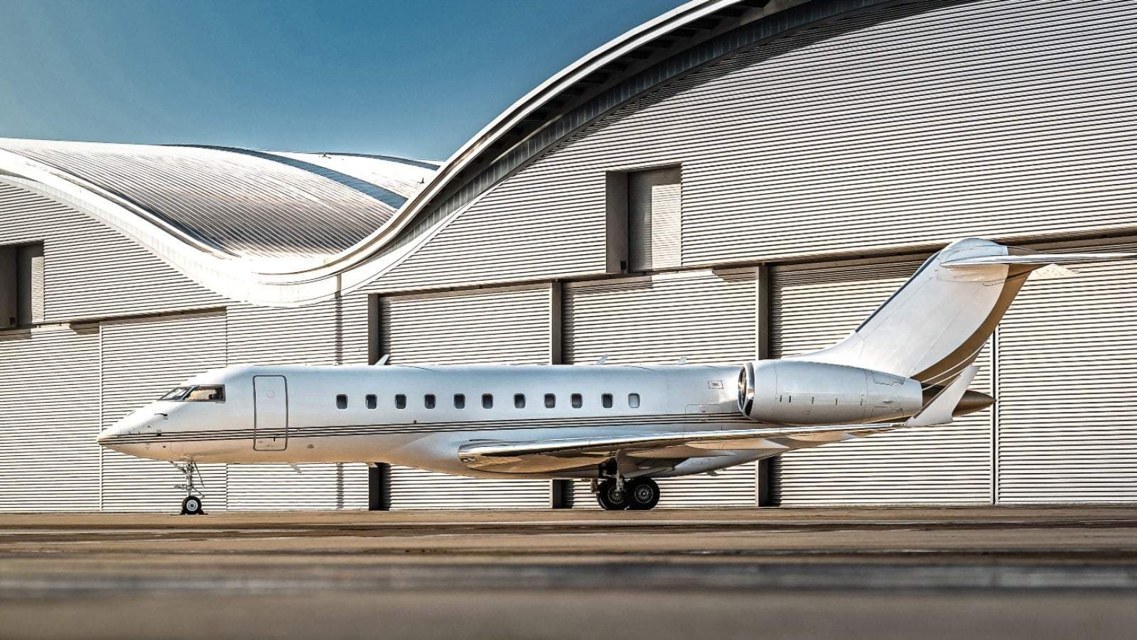 White private jet parked on tarmac in front of a modern airport hangar near President Obiang Nguema International Airport, Mengomeyén, Equatorial Guinea