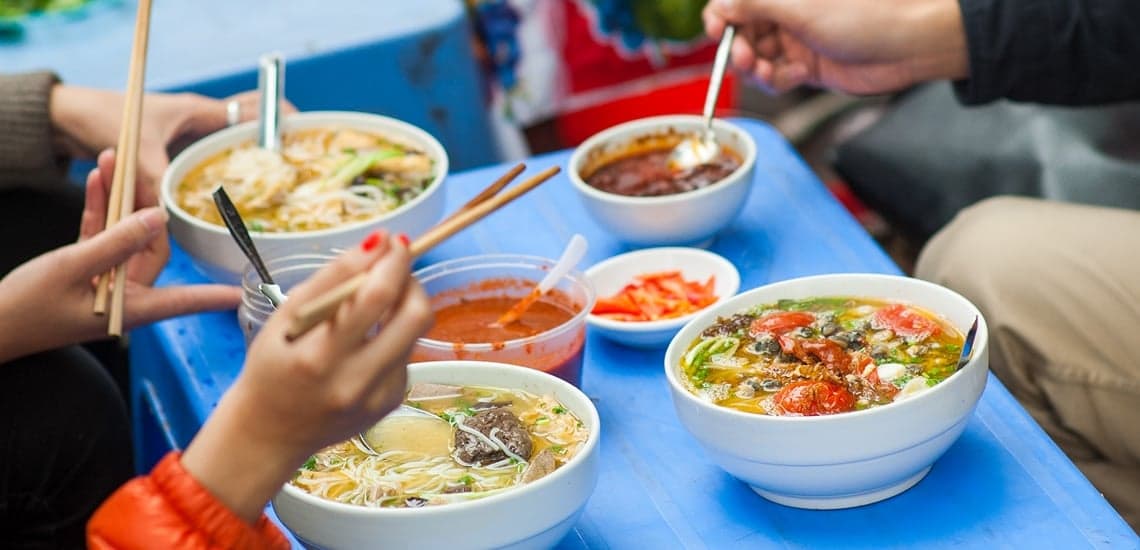 Cultural etiquette while eating street food in Asia, including local gestures and manners