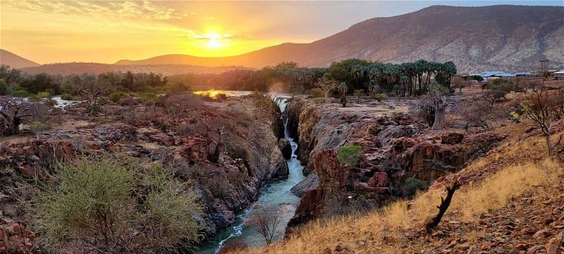 Epupa Falls Lodge exterior with thatched roof and river view, located in Epupa Constituency, Namibia